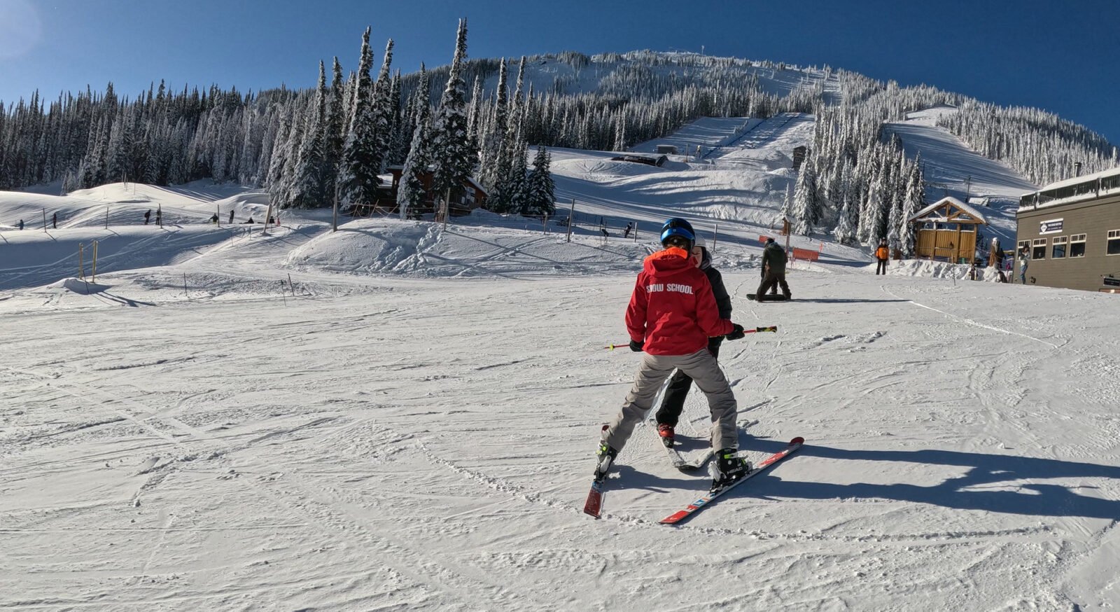 Apex Mountain Resort in Canada - a man riding a snowboard down a snow covered slope.