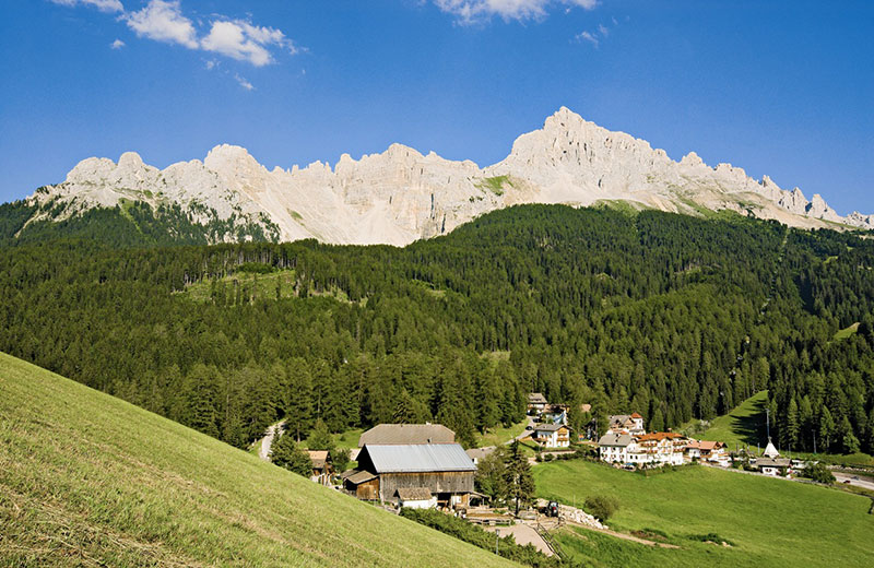 Nova Ponente in Italy - the mountains are covered with trees.