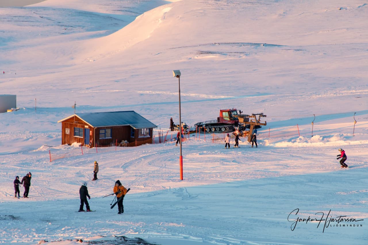 Húsavík in Iceland - a group of people skiing down a snowy hill.
