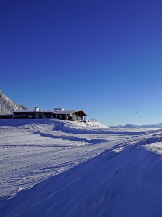 Sachrang in Germany: a snow covered ski slope with a building in the background.