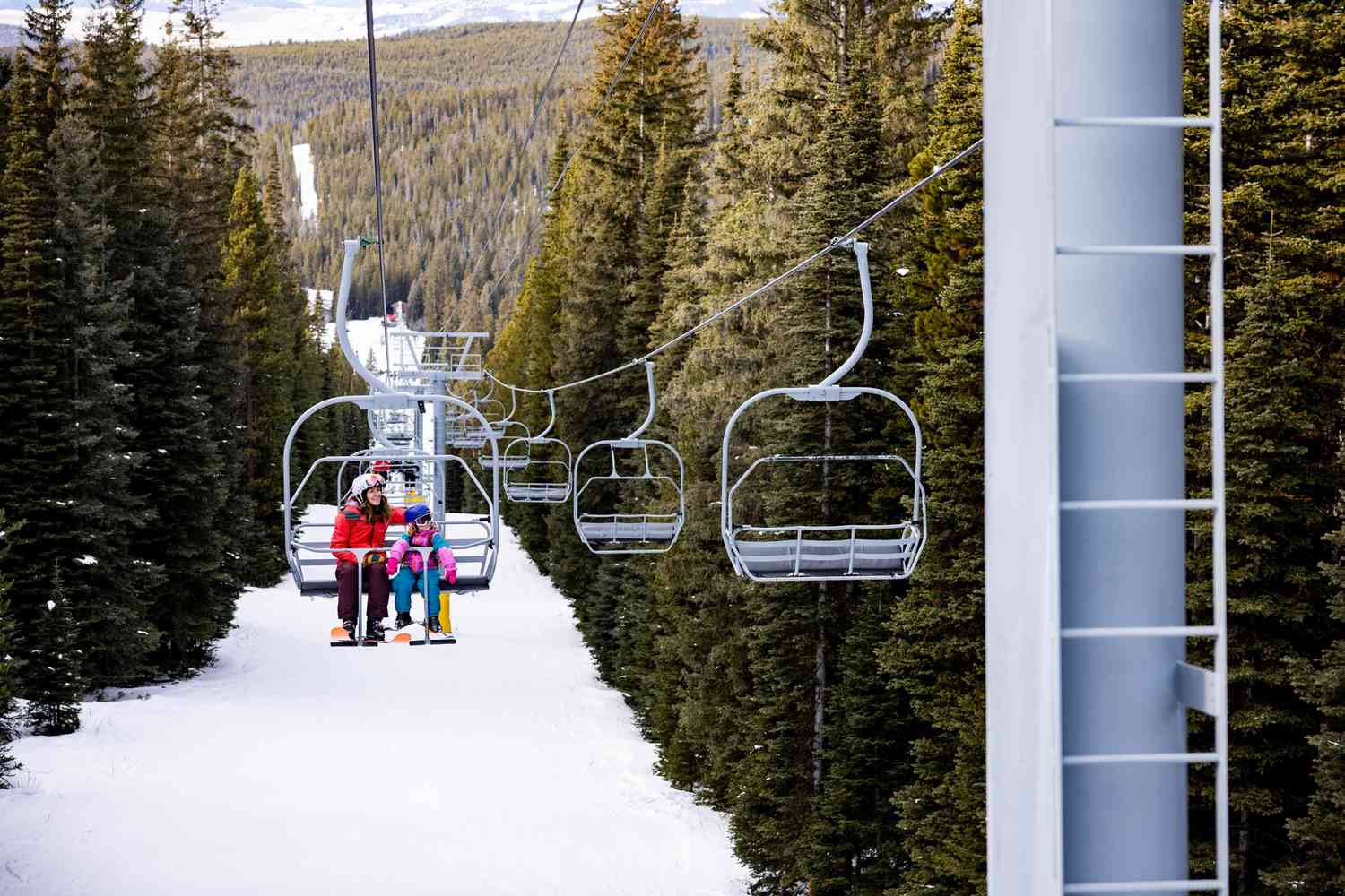 Red Lodge Mountain in USA - two people on a ski lift in the mountains.