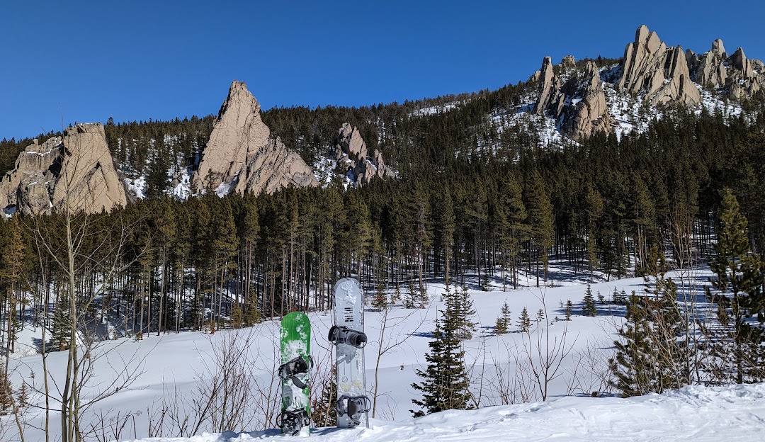 Red Lodge Mountain in USA - a person standing in the snow near some trees.