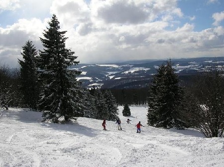 Hoher Meissner – Eschwege | ​Hessisch Lichtenau in Germany - a group of people skiing down a snow covered slope.
