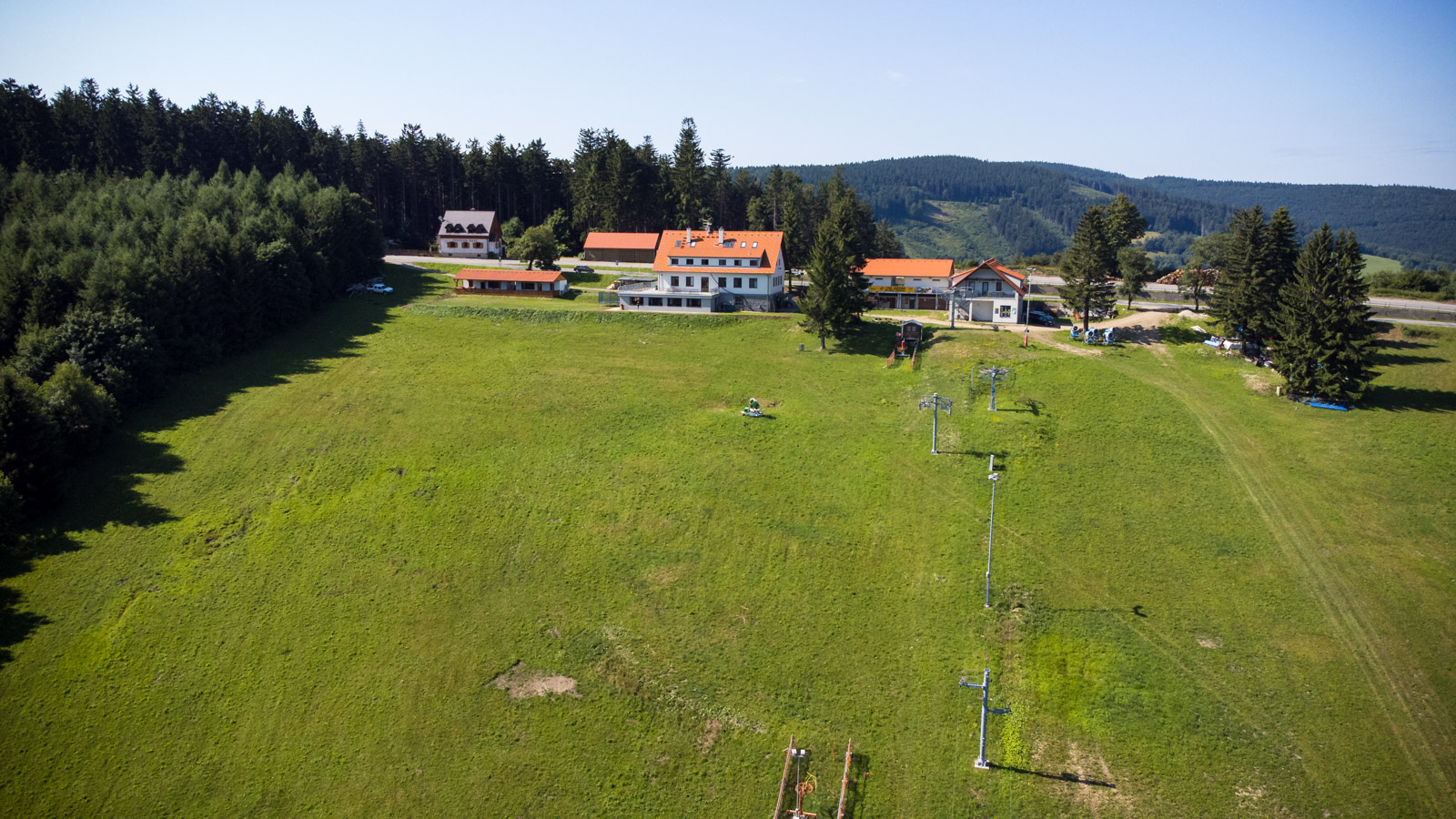 Bílé Karpaty – Mikulčin Vrch in Czech Republic - a large green field with a house in the background.