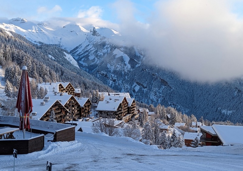 Ski resort in Anzere, Valais, Lemanic Region, Switzerland on a winter day. The stunning winter scenery includes snowy slopes bustling with winter sports activity, speckled with charming, snow-covered chalets.