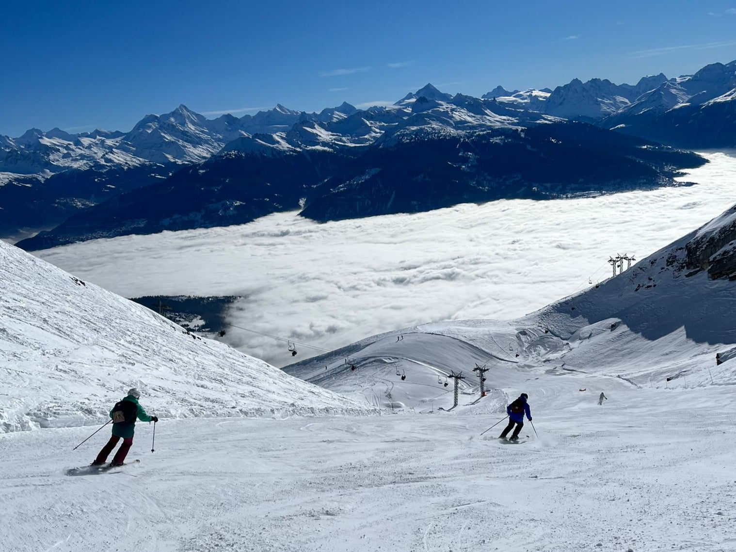 Anzere in Switzerland - a group of people skiing down a snow covered mountain.