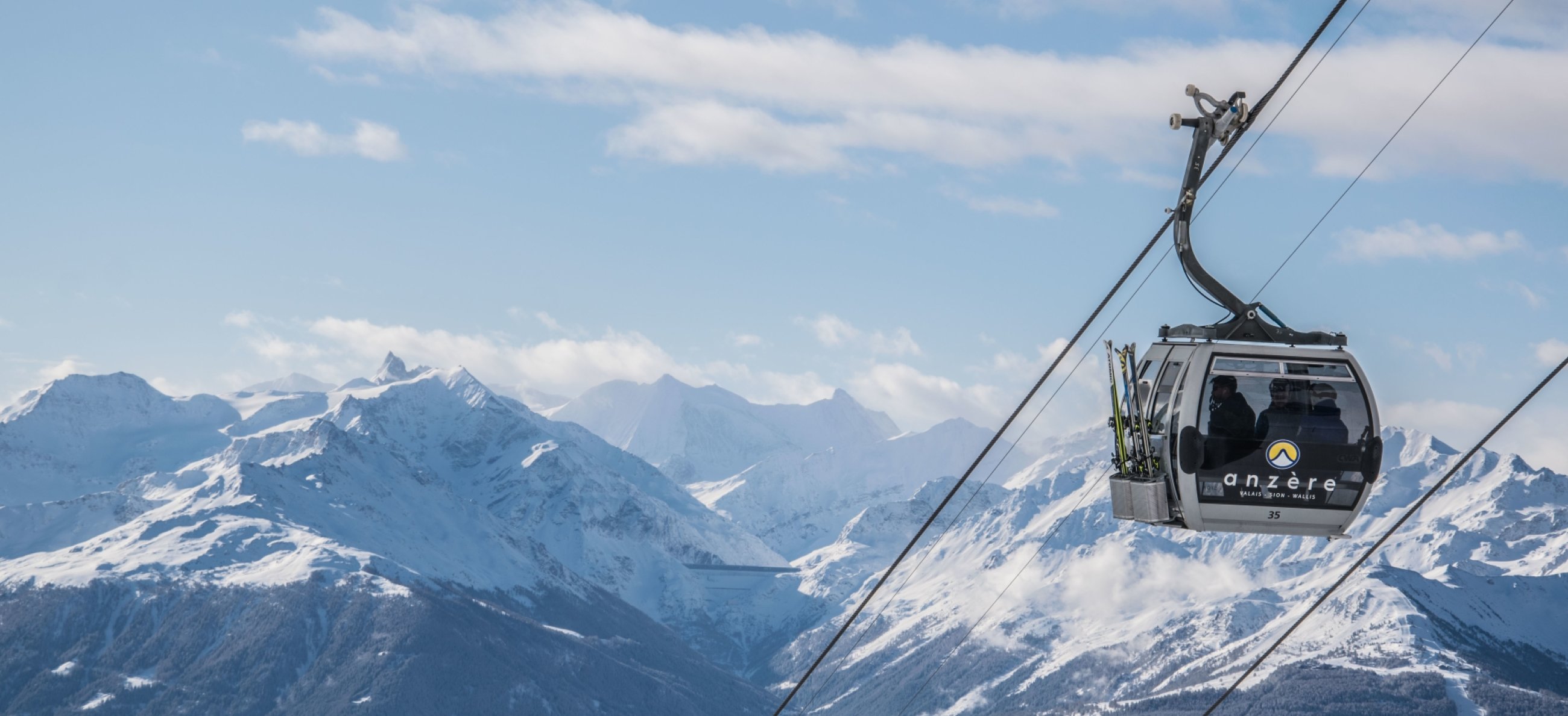 A skier explores the snowy slopes in Anzere Switzerland. The surrounding ski lift and resort reinforce the vibrant winter sports scene nestled among the stunning mountain peaks.