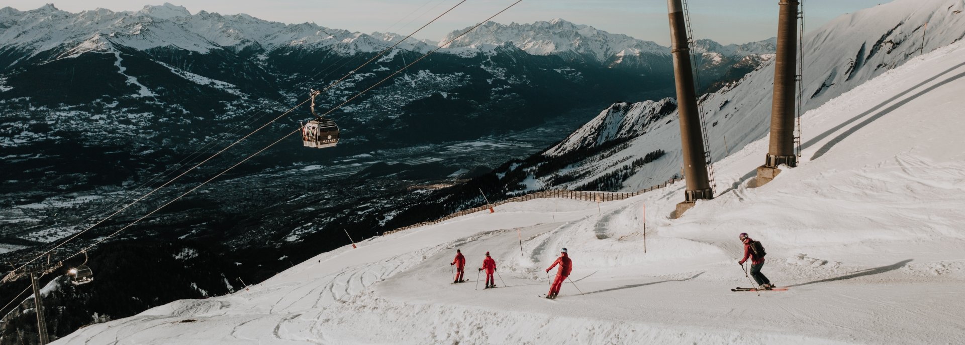Anzere in Switzerland - a group of people skiing down a snowy mountain.