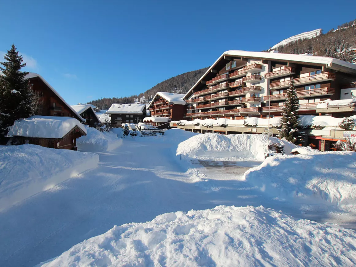 Anzere in Switzerland: a snow covered street with buildings in the background.