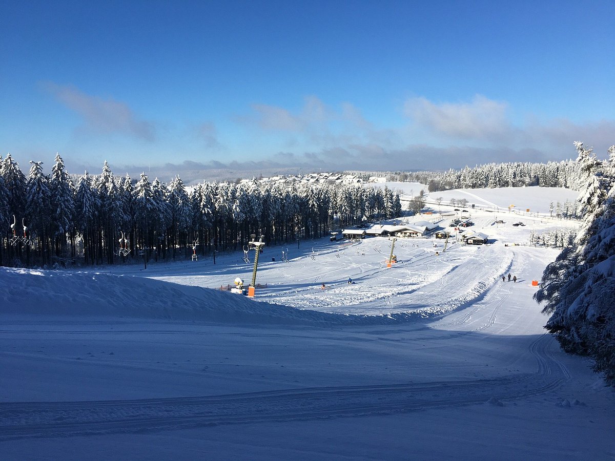 Winterberger Nordhang in Germany - a snow covered ski slope with trees in the background.