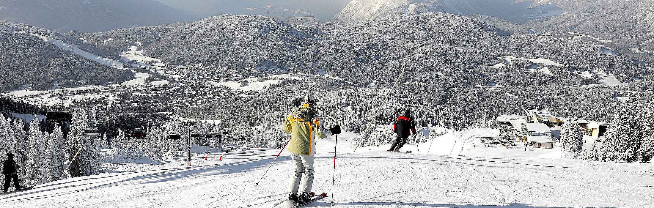 Neuleutasch in Austria - a group of people skiing down a mountain.