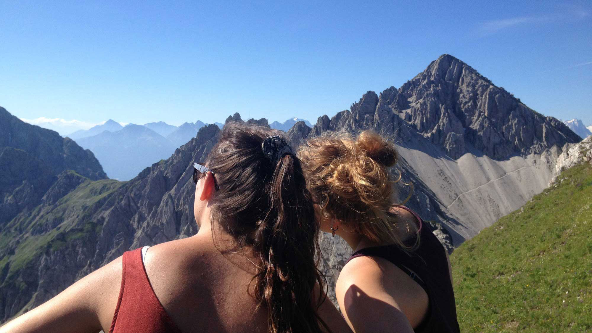 Neuleutasch in Austria - two women standing on a mountain looking at the mountains.