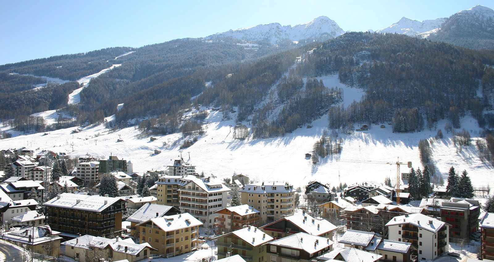 Aprica in Italy - a view of a snowy town with mountains in the background.