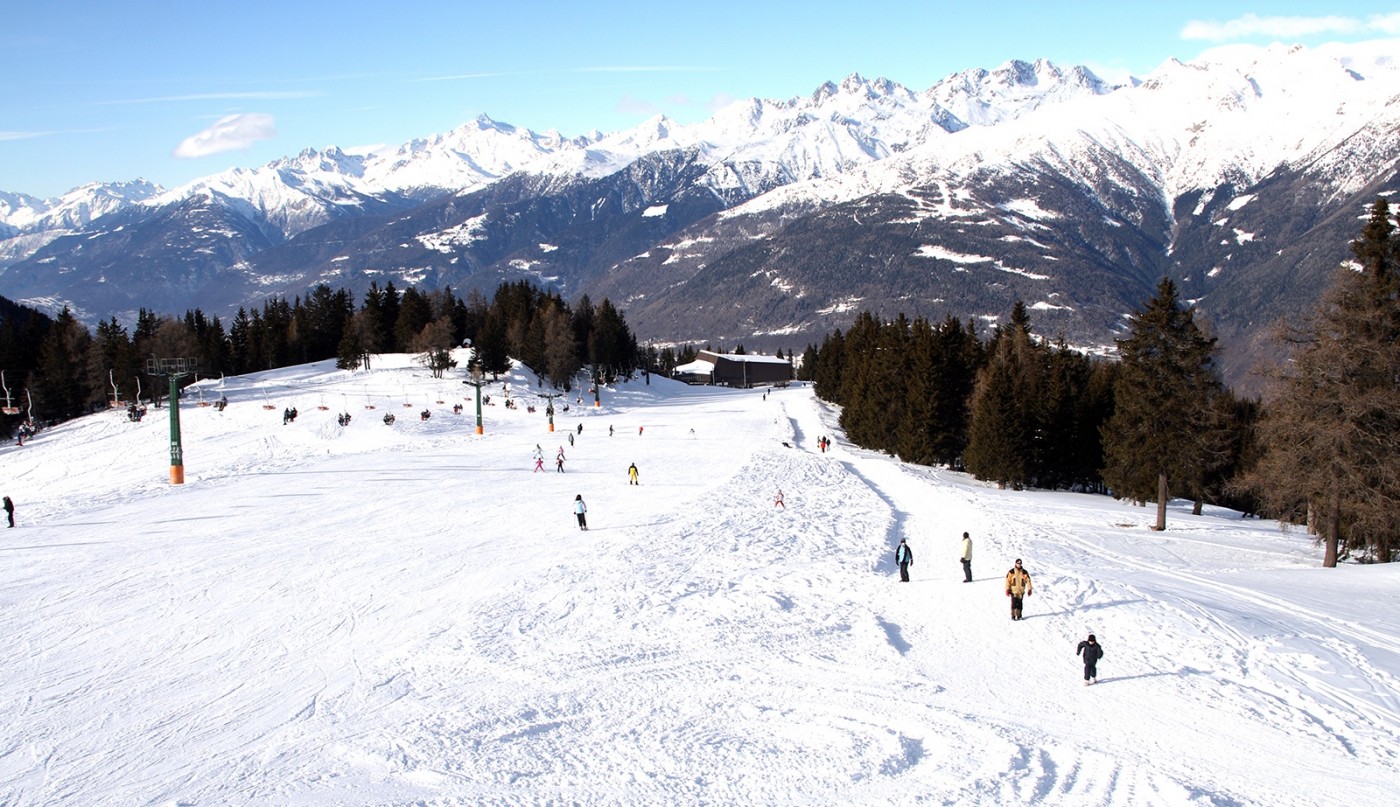 Aprica in Italy - a group of people skiing down a snowy slope.
