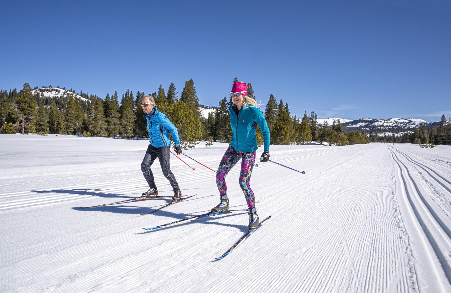 Bear Valley in USA - two people skiing down a snow covered slope.