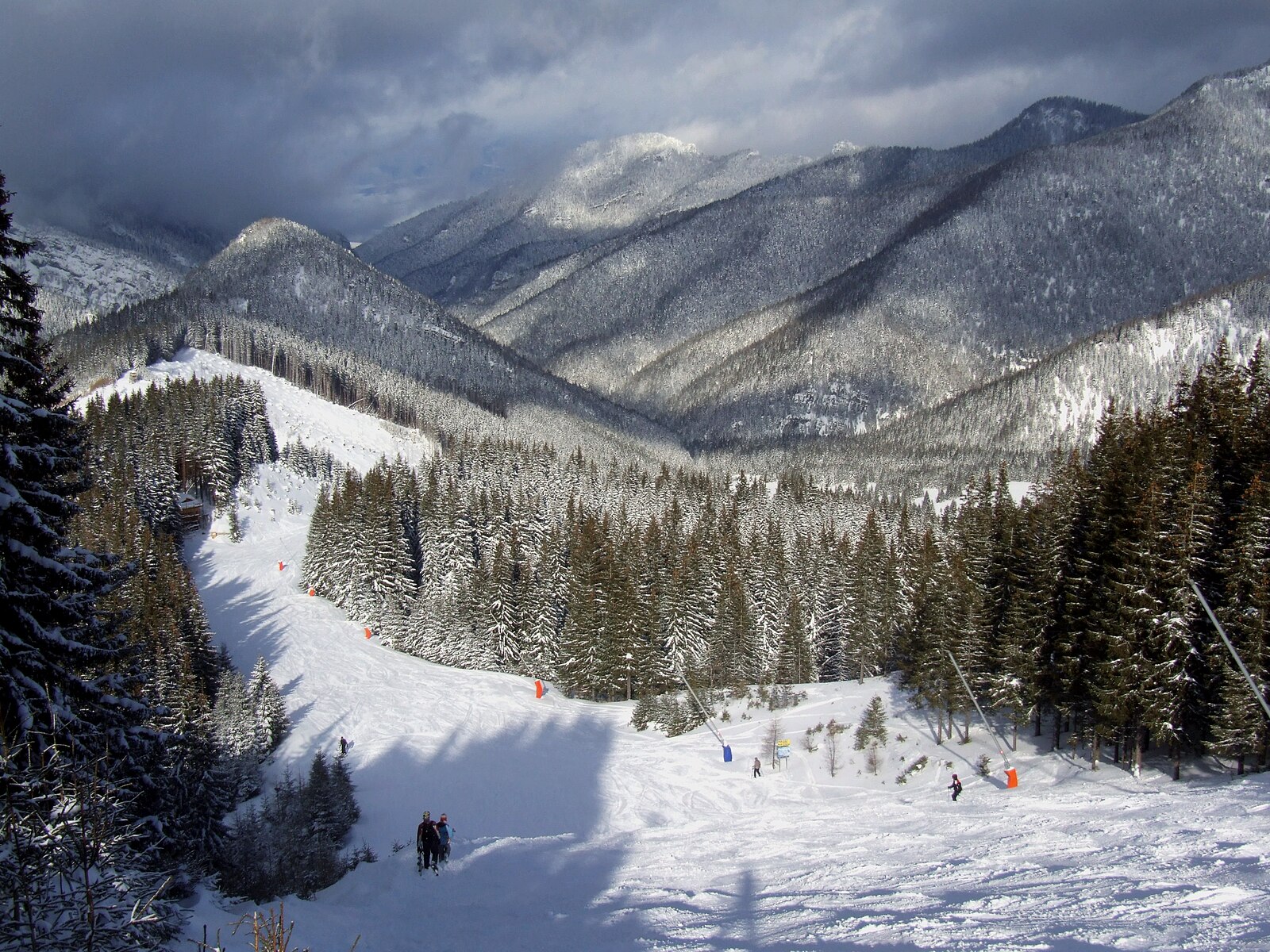Sjezdovka in Czech Republic - a group of people skiing down a snowy slope.