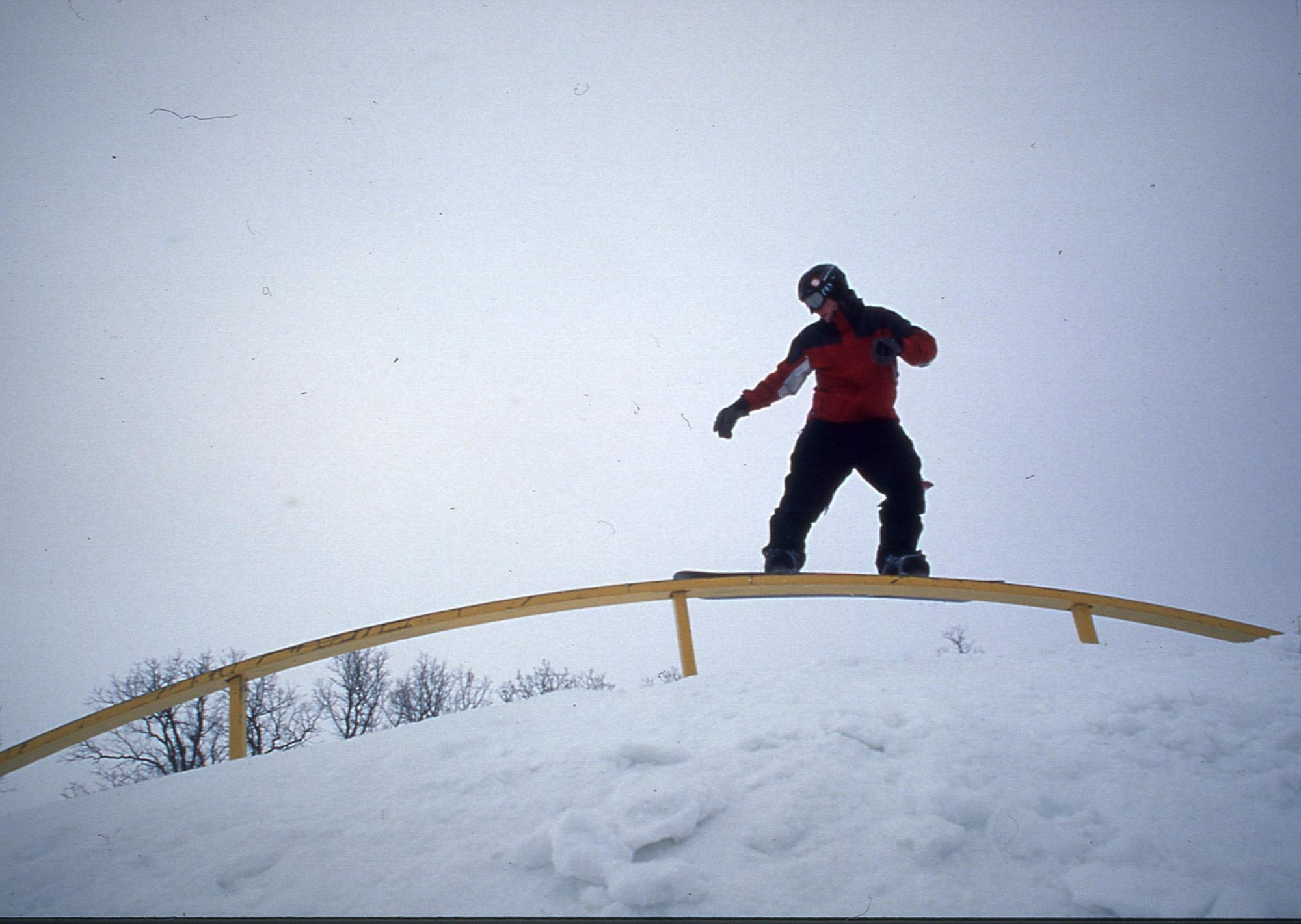 A snowboarder enjoying a thrilling descent on the snow-filled slopes of Stony Mountain in Manitoba Canada. The stark white of the snow contrasts beautifully with the surrounding landscape.