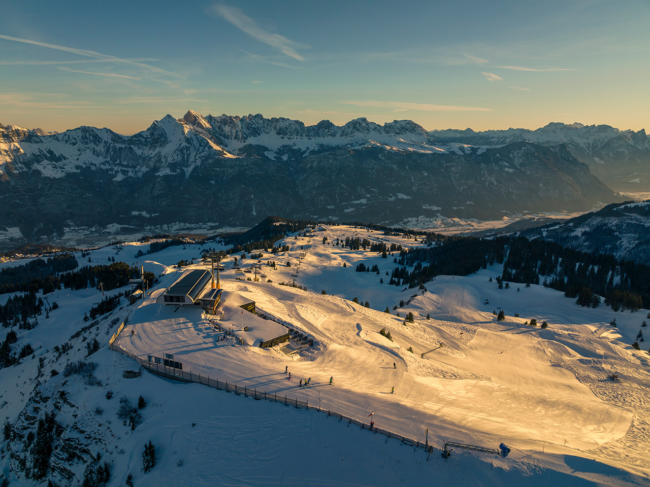 Breathtaking view of Flumserberg in Heidiland, Eastern Switzerland, highlighted by a bustling winter sports scene with skiers enjoying the pristine, snow-covered slopes of the ski resort.
