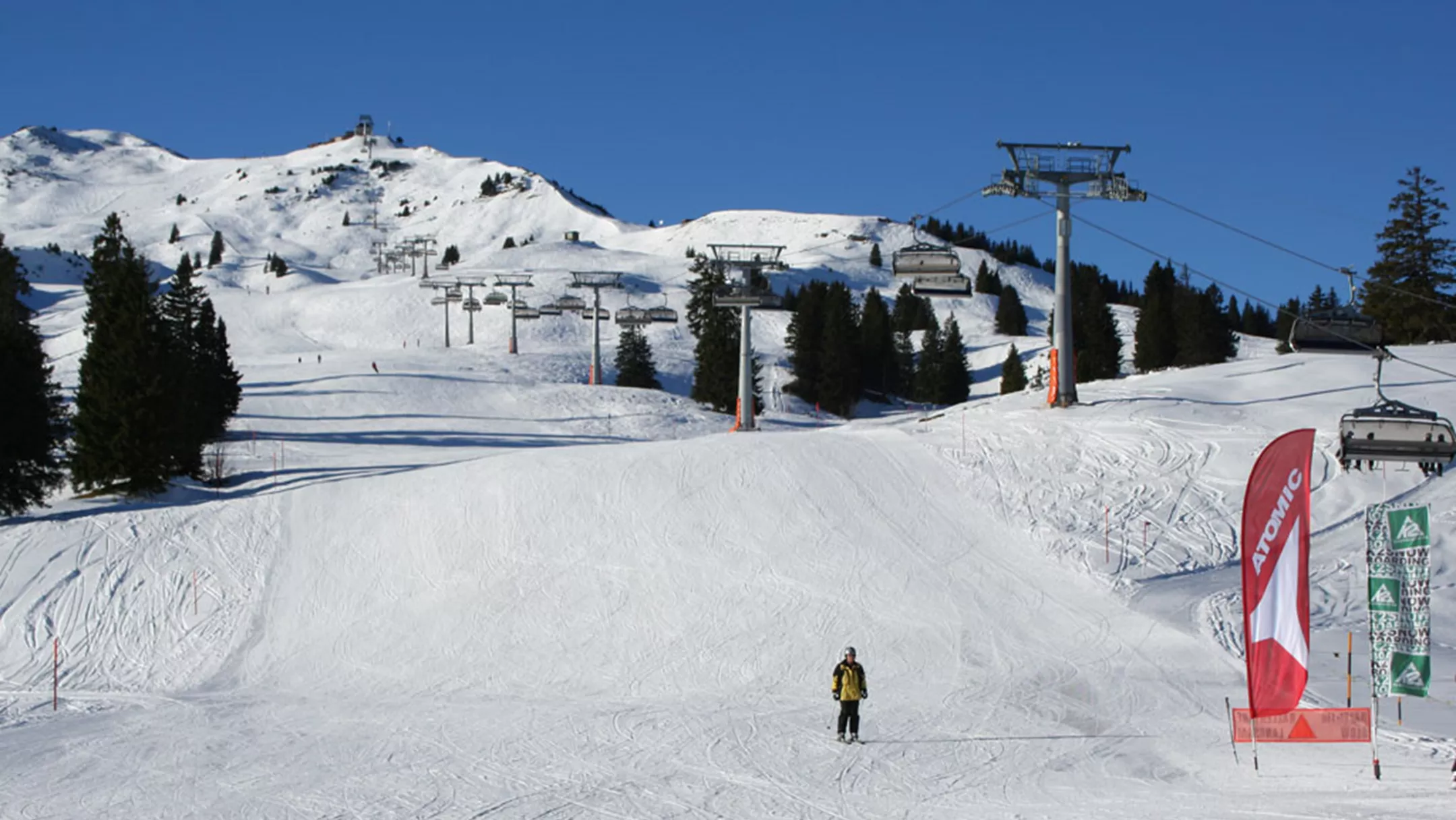 A bustling winter scene at Flumserberg ski resort situated in the idyllic Heidiland of Eastern Switzerland featuring skiers enjoying the ski tracks a ski lift in operation and a cozy chalet nestled in the snow-draped landscape.