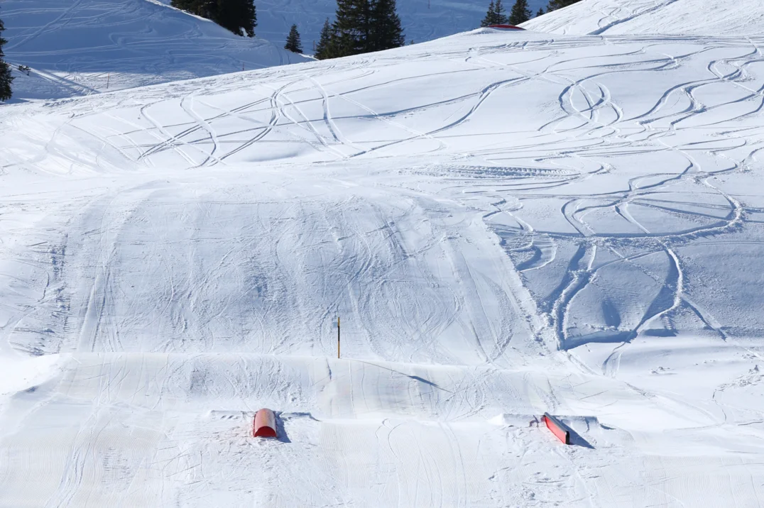 Skier and snowboarder enjoying the snow-covered slopes at Flumserberg ski resort in Heidiland Eastern Switzerland amidst a beautiful winter sports scene.