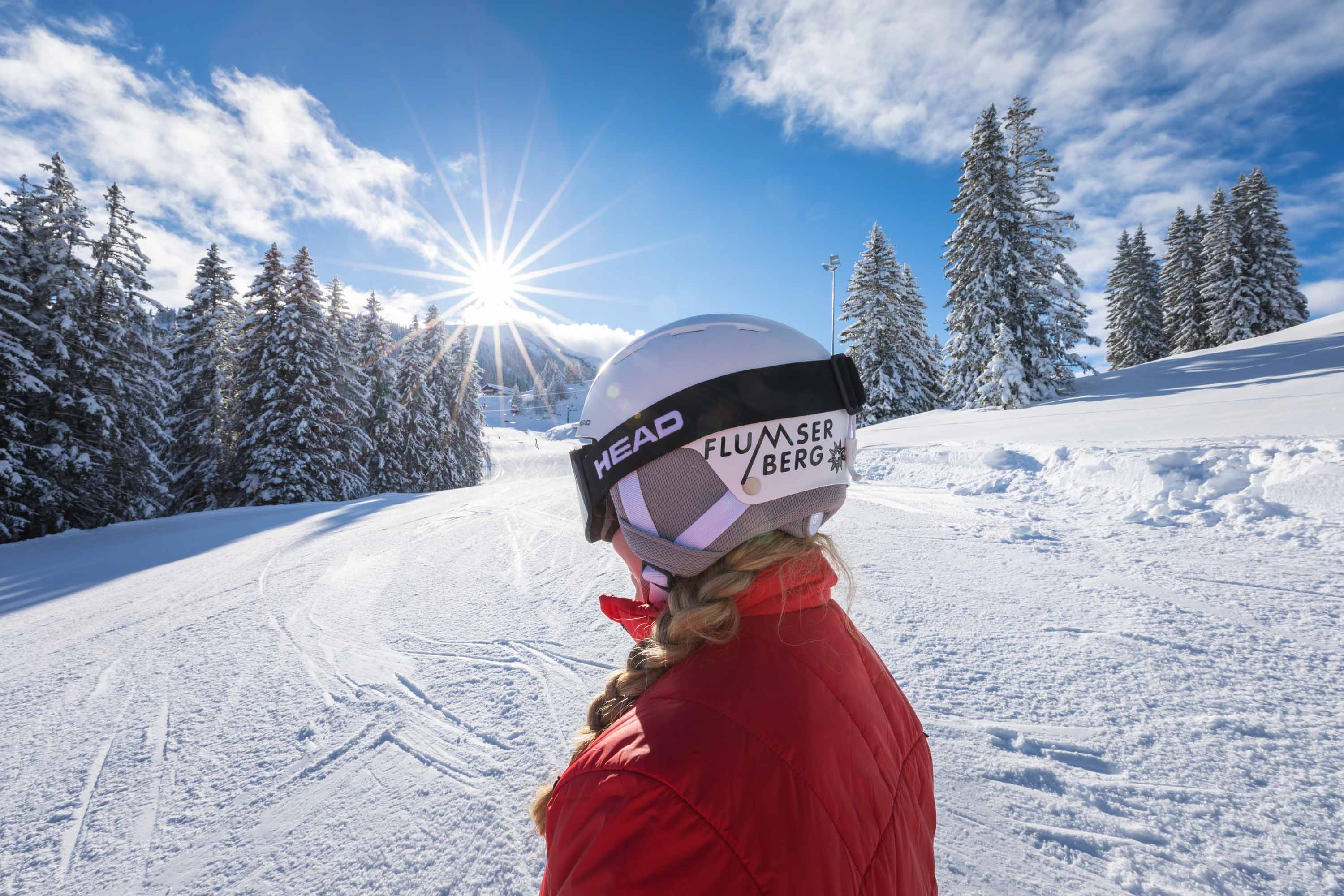 A skier and a snowboarder enjoying a sunny day at the winter sports scene in Flumserberg ski resort, located in Eastern Switzerland's Heidiland region.