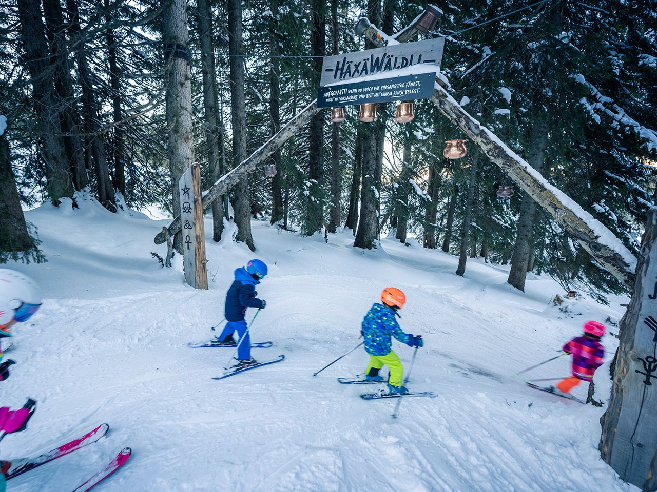 A winter sports scene in Flumserberg, Eastern Switzerland depicting families and groups enjoying skiing at a bustling resort.