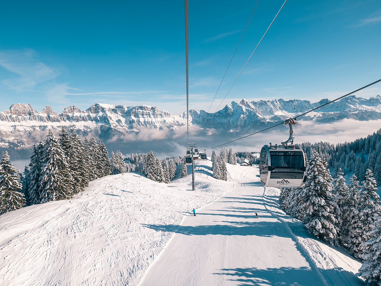 Ski lift and chalet amidst a vibrant winter scene at the ski resort of Flumserberg, Heidiland, in Eastern Switzerland.