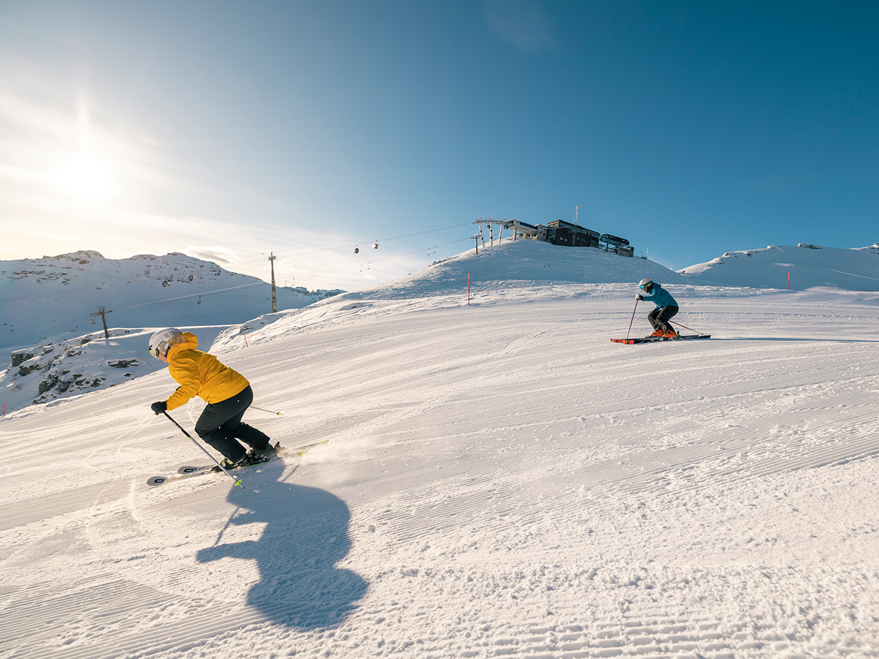 Winter sports scene at Flumserberg in Heidiland, Eastern Switzerland, featuring a skier and a group of people enjoying skiing at a ski resort.