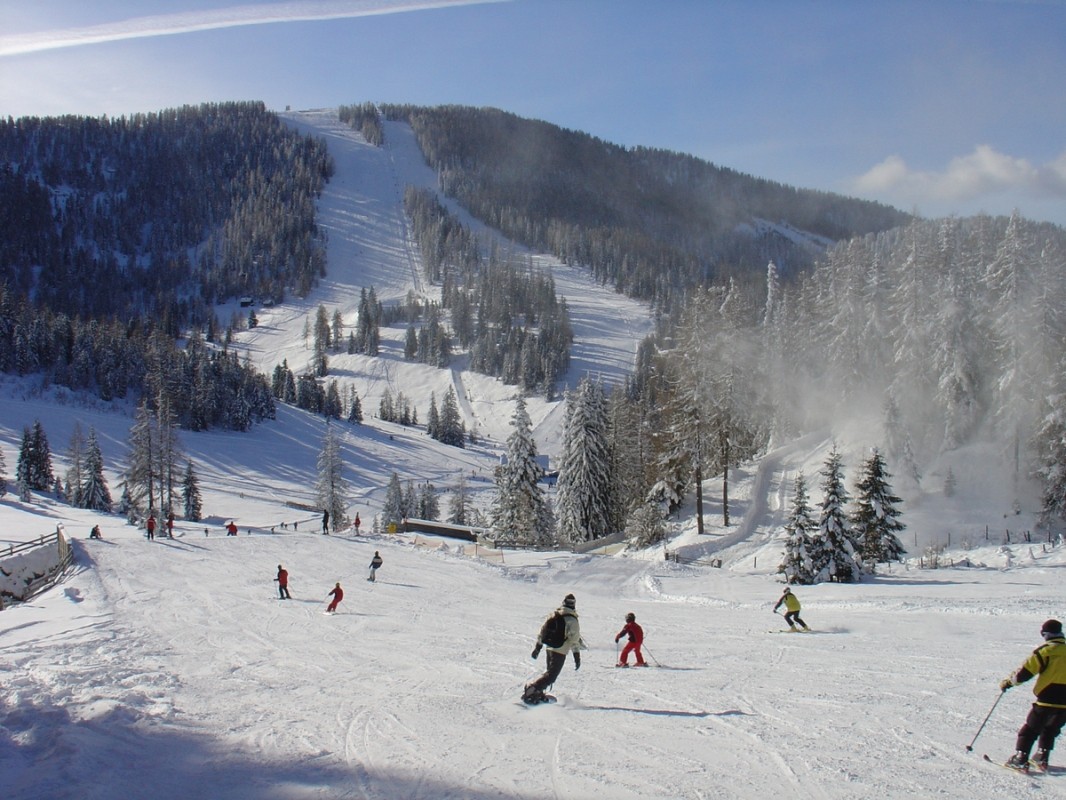 Hochrindl – Sirnitz in Austria - a group of people skiing down a snowy slope.