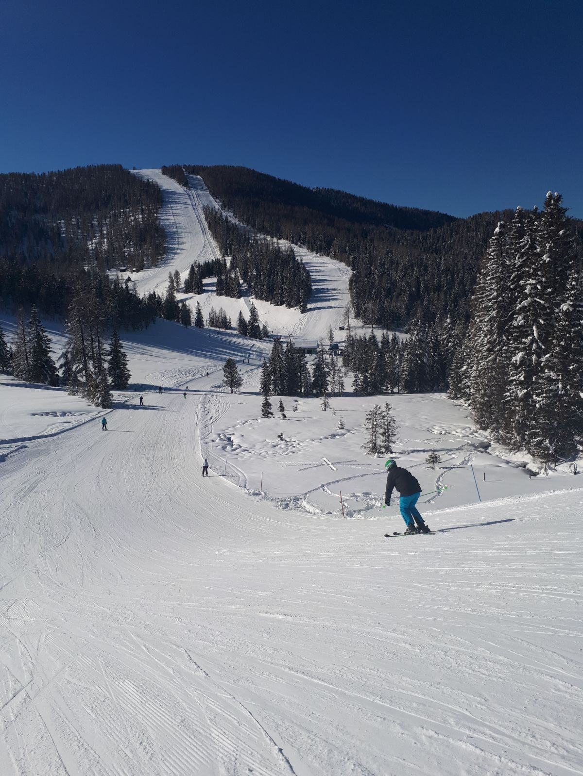 Hochrindl – Sirnitz in Austria - a person riding a snowboard down a snowy slope.