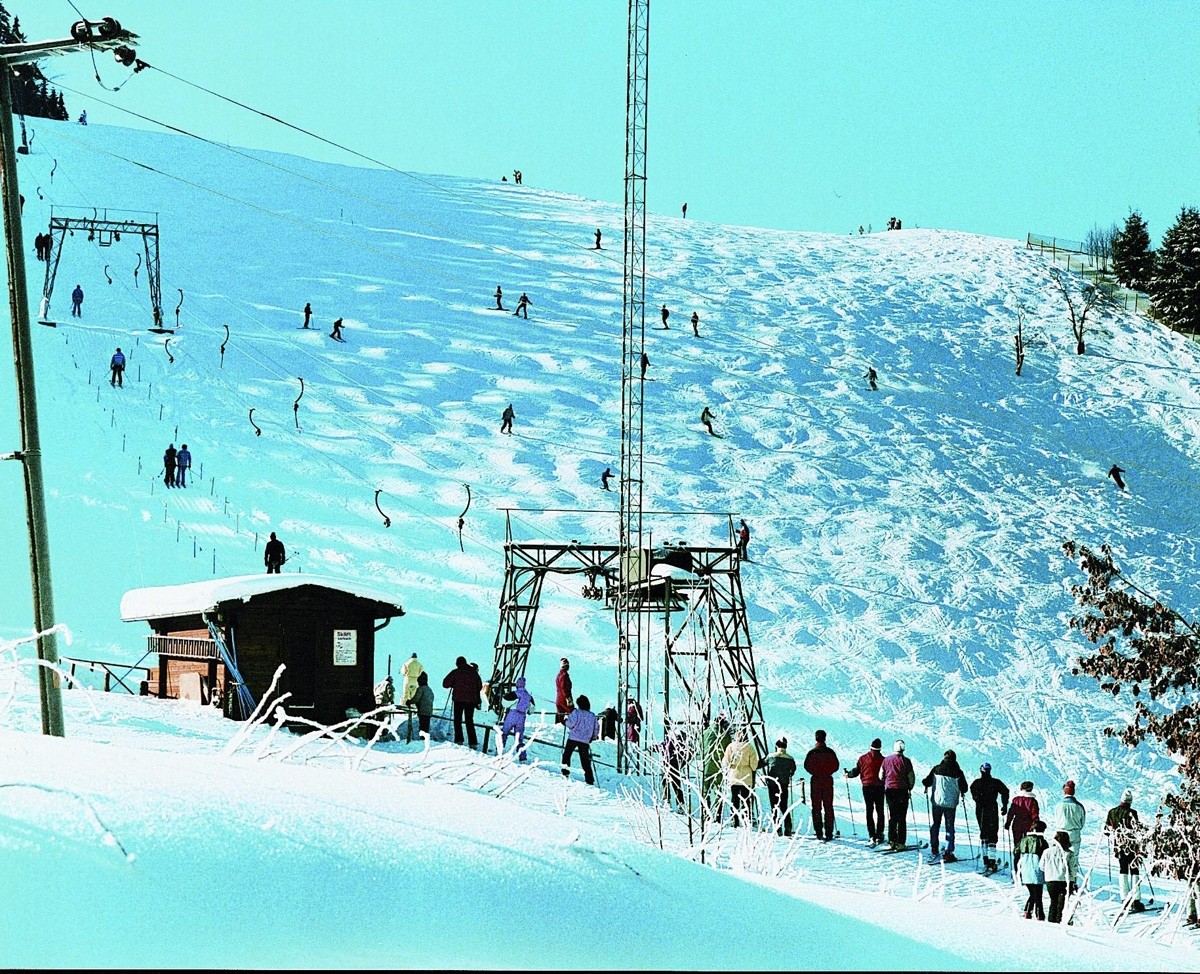 Mühlwiese – Lerbach in Germany - a group of people skiing down a snowy hill.