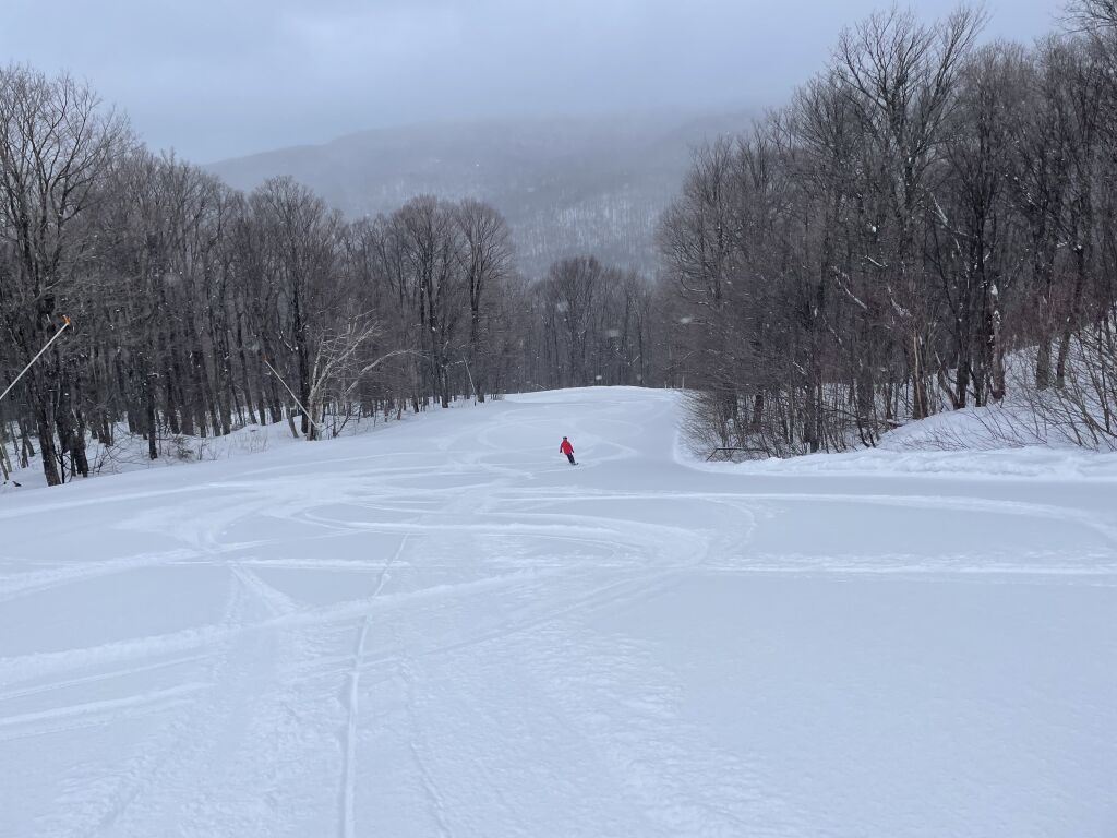 Smugglers' Notch Resort in USA - a person skiing down a snow covered hill.