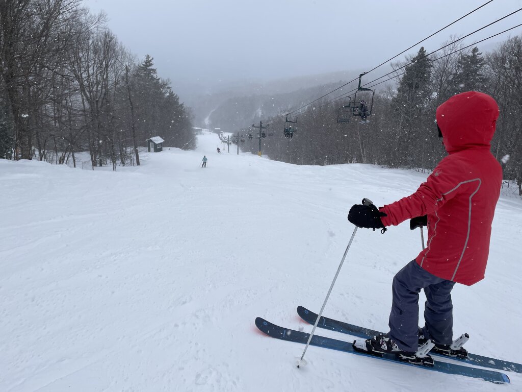 Smugglers' Notch Resort in USA - a person in a red jacket skiing down a hill.