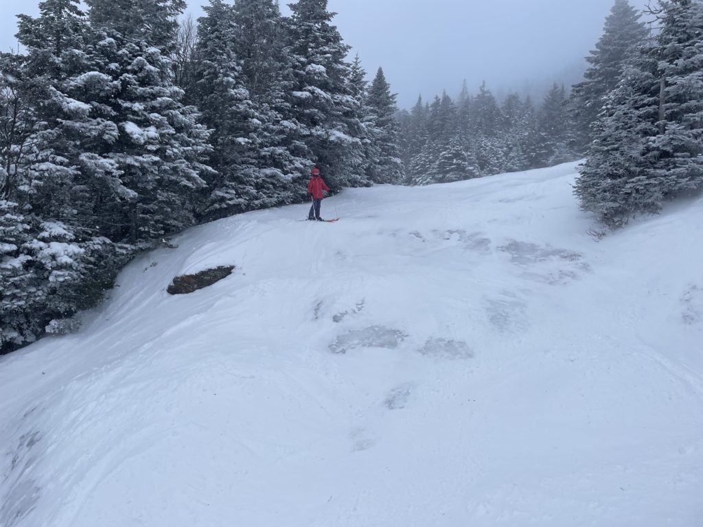Smugglers' Notch Resort in USA - a person skiing down a snow covered slope.