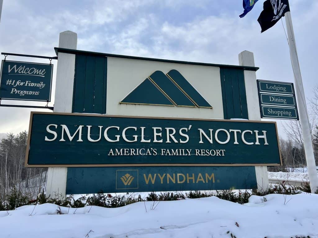 Smugglers' Notch Resort in USA: a sign in front of a building in the snow.