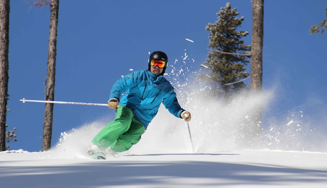 49° North Mountain Resort in USA - a man in a blue jacket skiing down a hill.