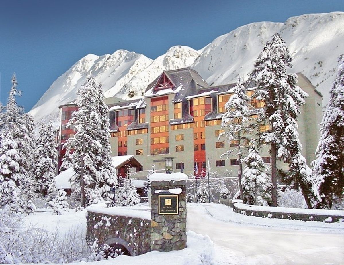 Alyeska Resort – Girdwood in USA: a snowy scene of a hotel in the mountains.