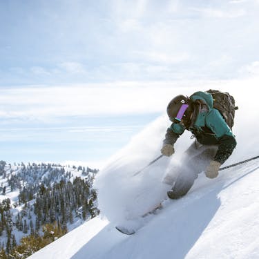Powder Mountain in USA - a person skiing down a snow covered mountain.