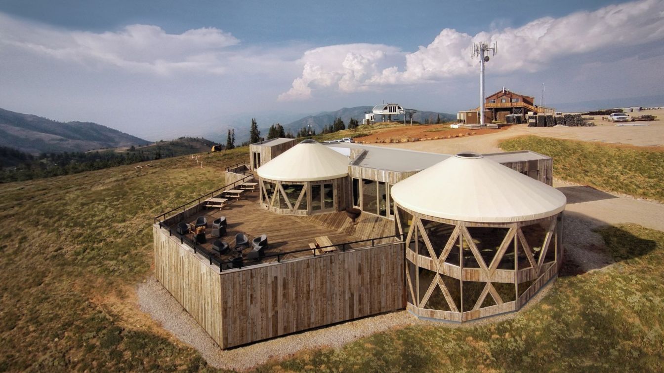 Powder Mountain in USA: a couple of people sitting outside of a building.