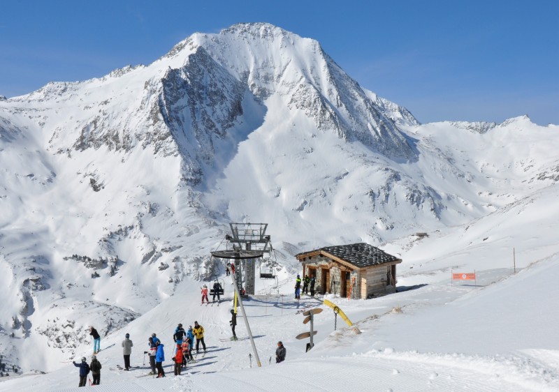 A serene winter scene at the Aussois ski resort in Savoie Mont Blanc France with a charming chalet and mountain hut amidst the snow-covered landscape bustling with winter sports activities.