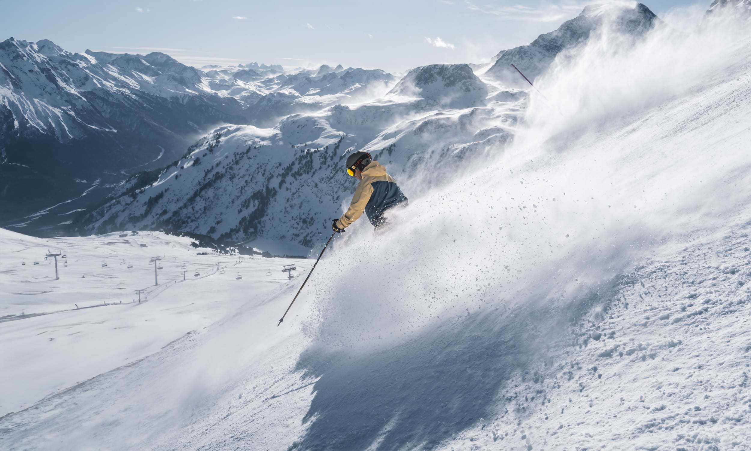 A skier enjoying a glorious day on the snowy slopes in Aussois, Savoie Mont Blanc, France. Breathtaking views of a ski resort and charming chalets complete the perfect winter sports scene.