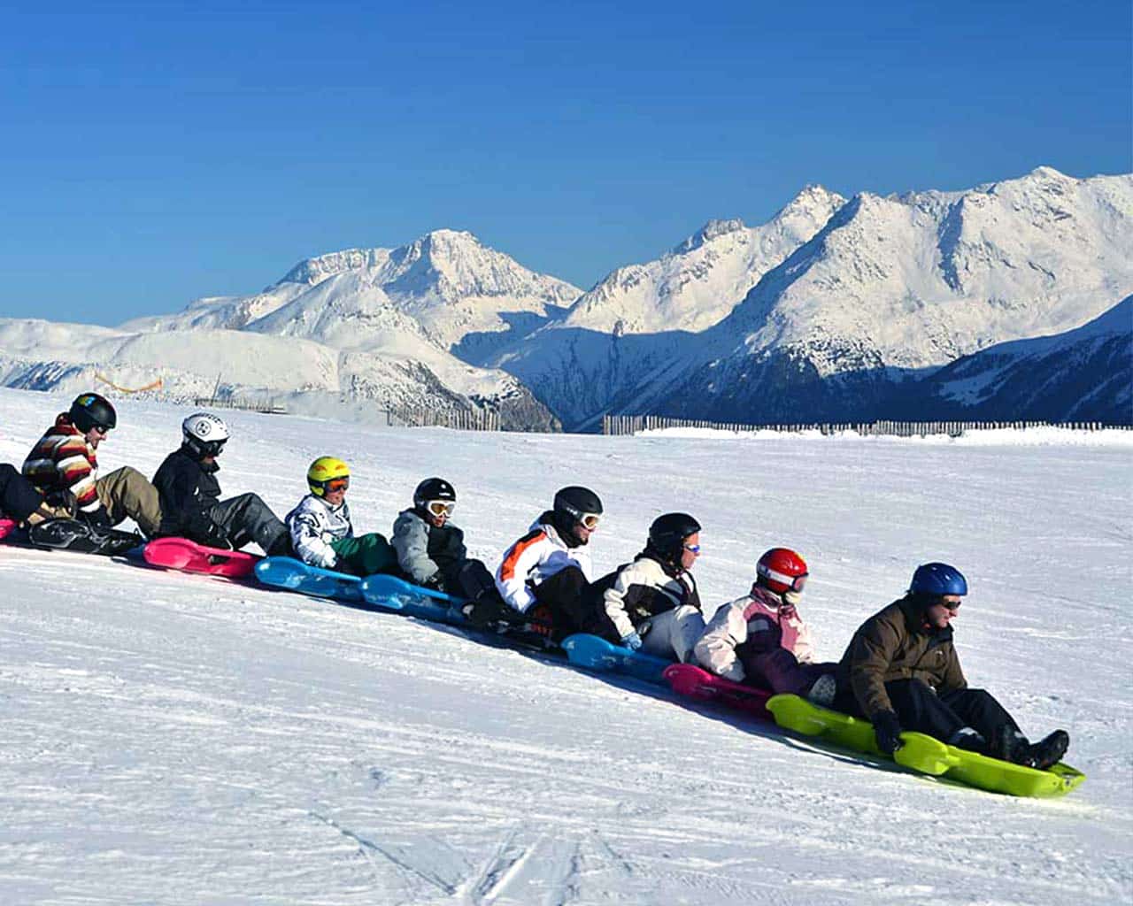 A lively scene at Aussois ski resort in Savoie Mont Blanc France featuring multiple skiers enjoying the winter sports facilities with a charming chalet in the background.