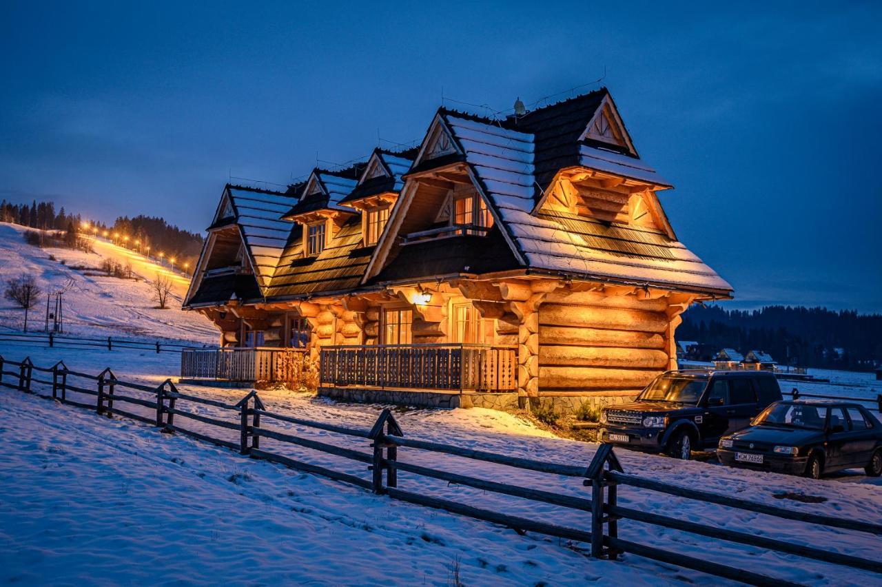 Przy Kolibie in Poland - a wooden house in the snow at night.