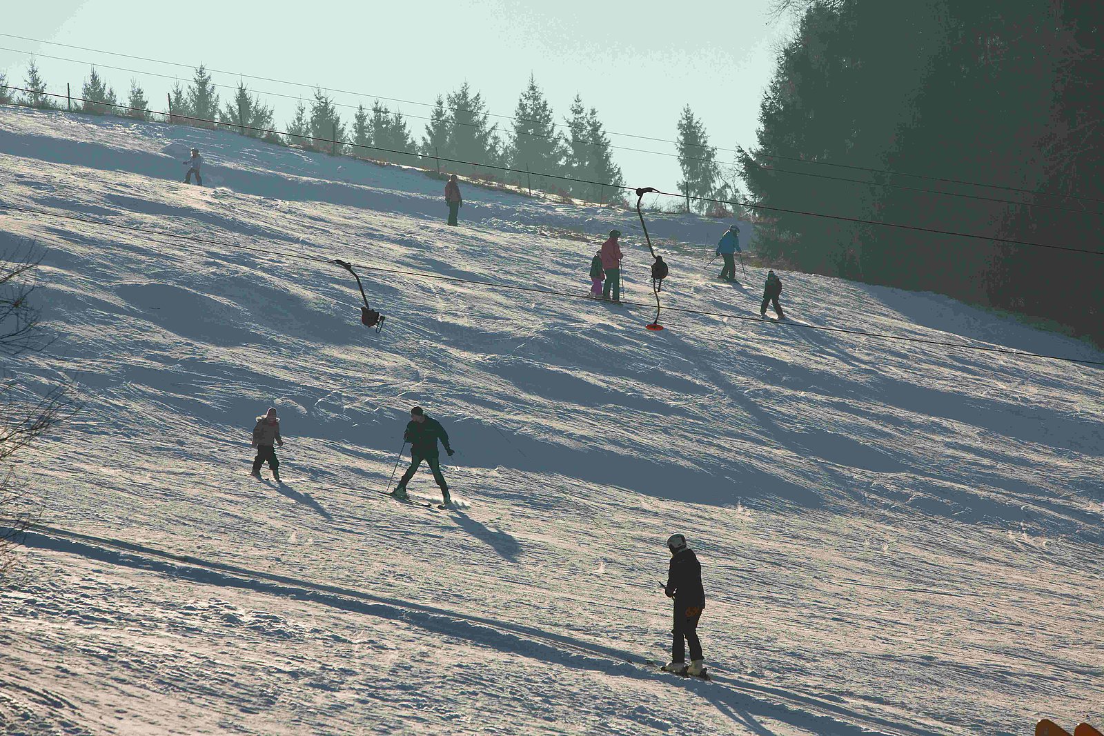 Monte Voggo – Voggenthal in Germany - a group of people riding down a snow covered slope.