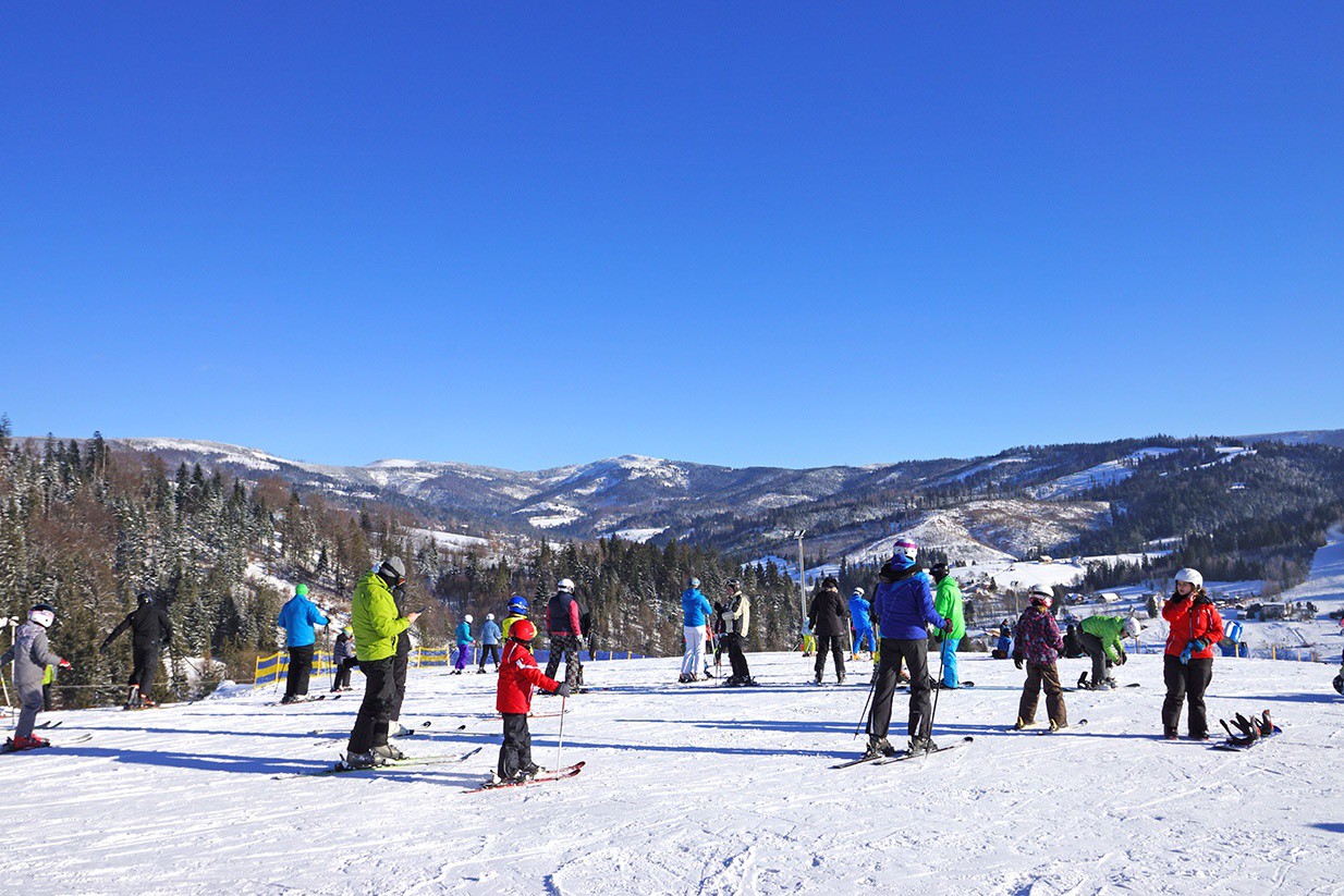 Polana Zielenska – Wisła in Poland - a group of people standing on top of a snow covered slope.
