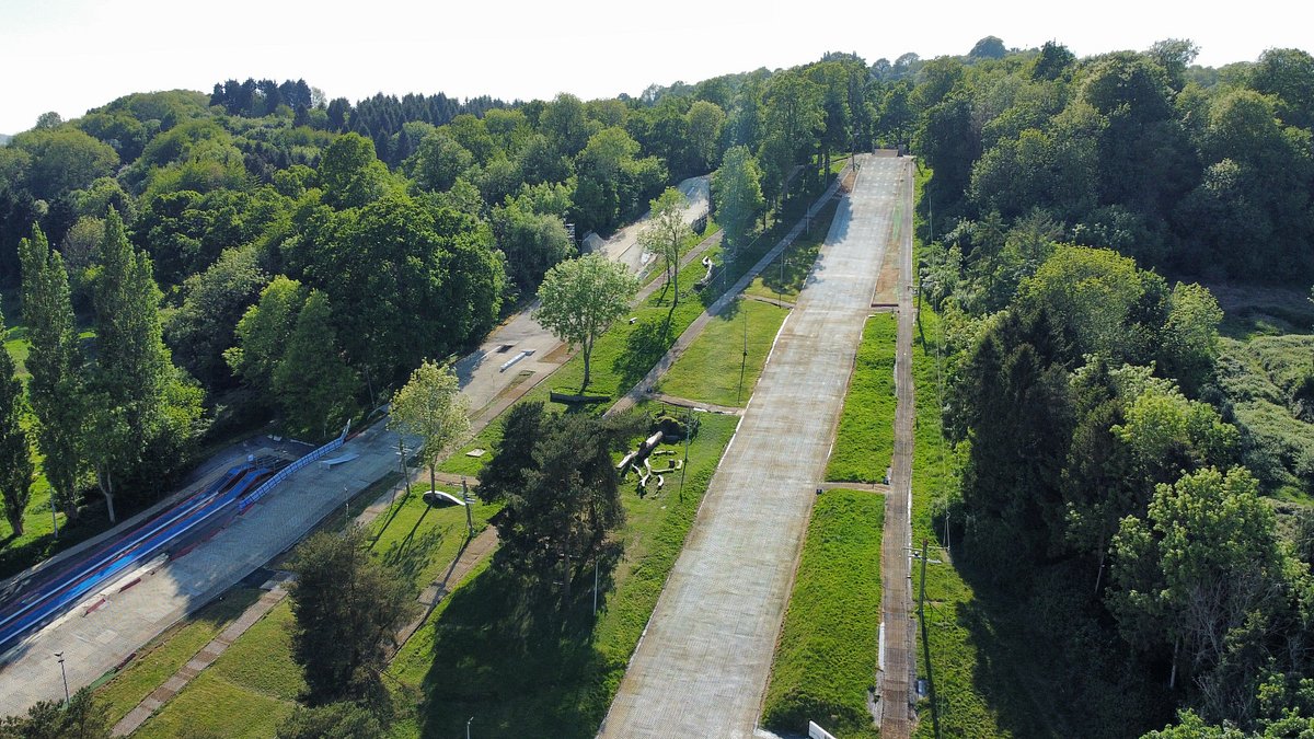 Gloucester Ski & Snowboard Centre in United Kingdom - a train traveling through a lush green forest.