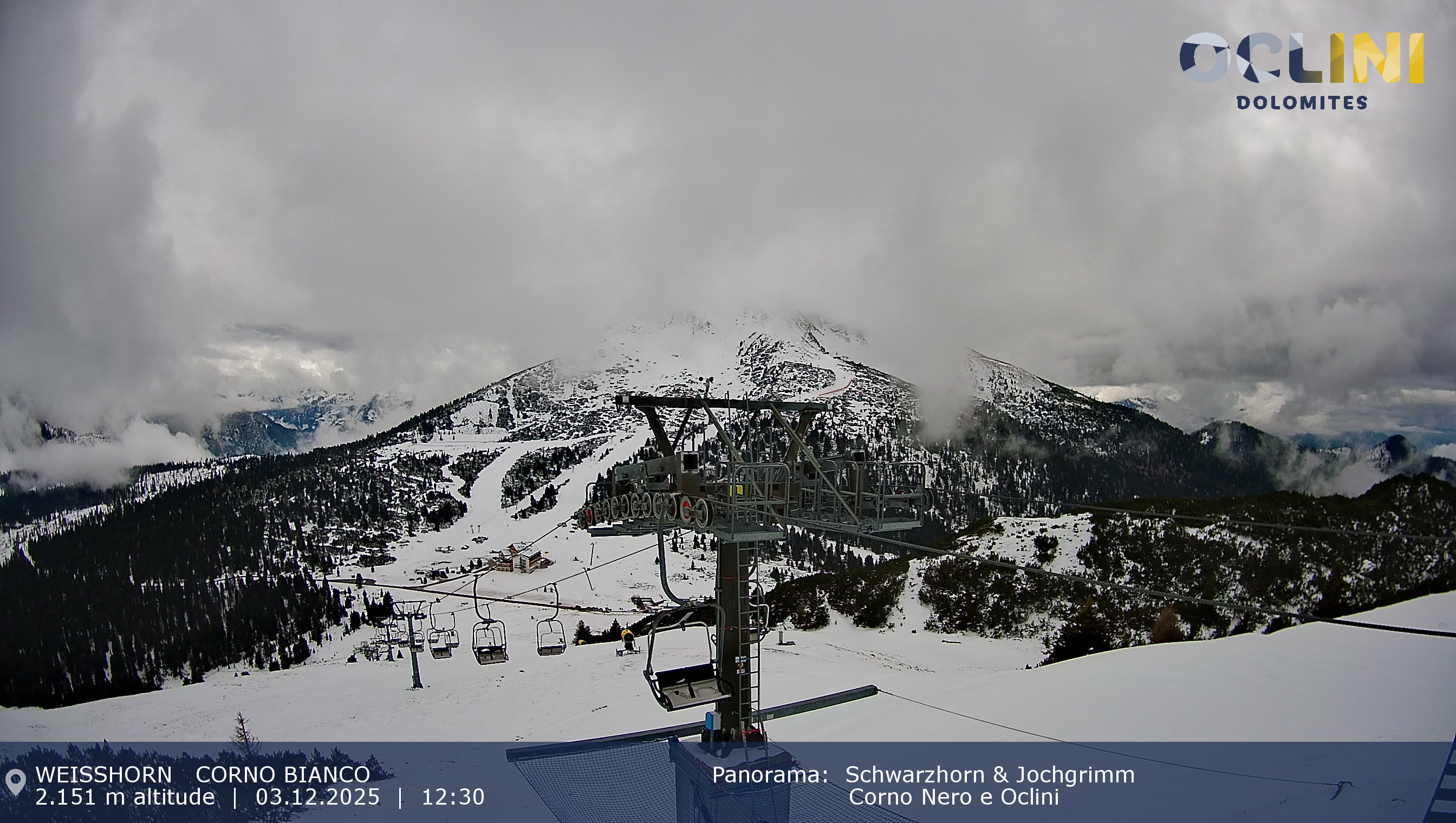 An scenic view of the Jochgrimm ski resort in Italy, capturing a lively winter sports scene. Snow-covered slopes and a ski lift accentuate the stunning winter scenery.