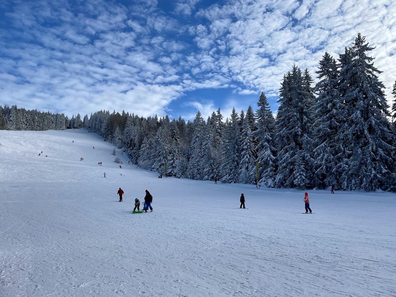 Vetrovala in Bulgaria - a group of people skiing down a snow covered slope.