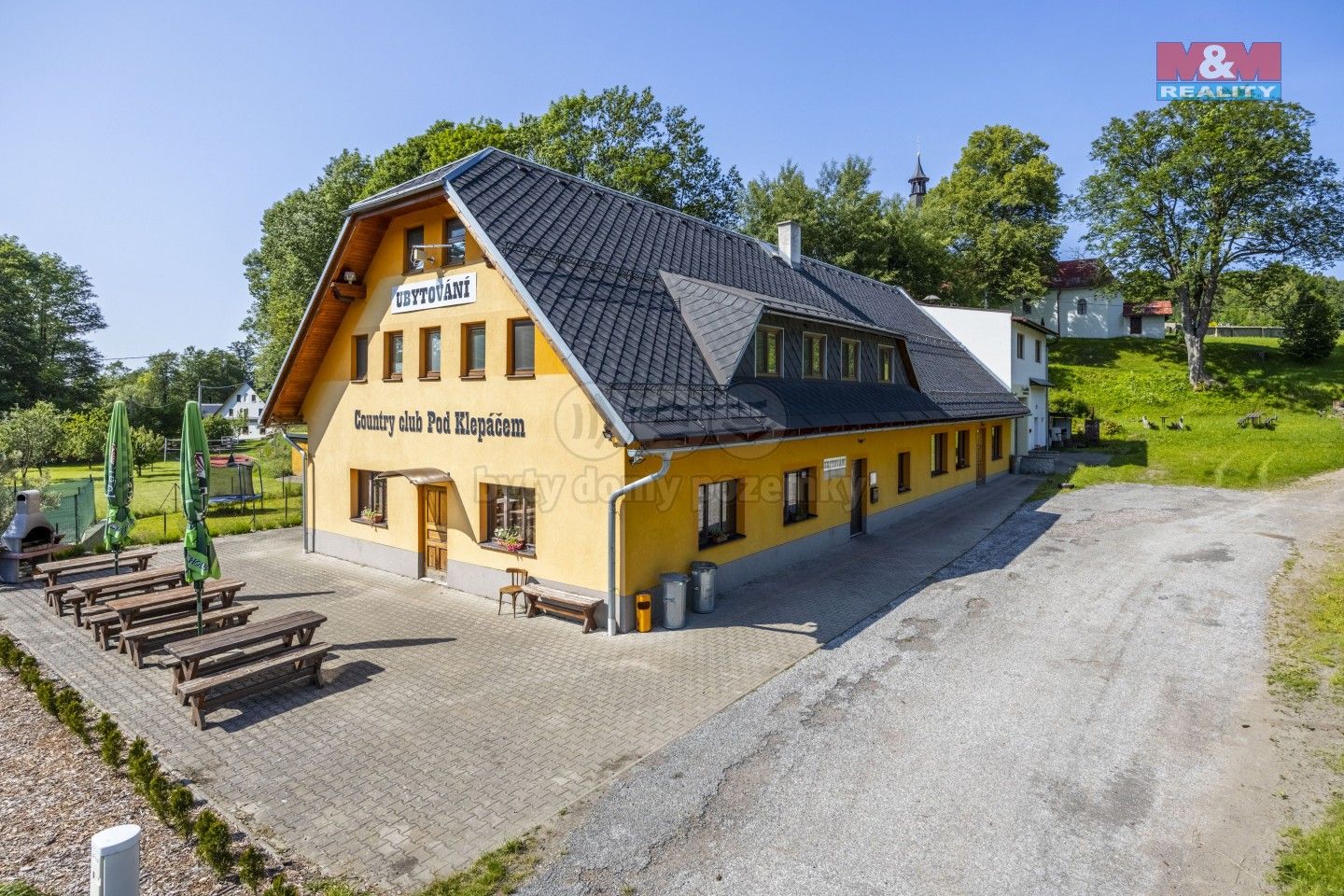 Šanov – Červená Voda in Czech Republic - a yellow house with a black roof in the countryside.