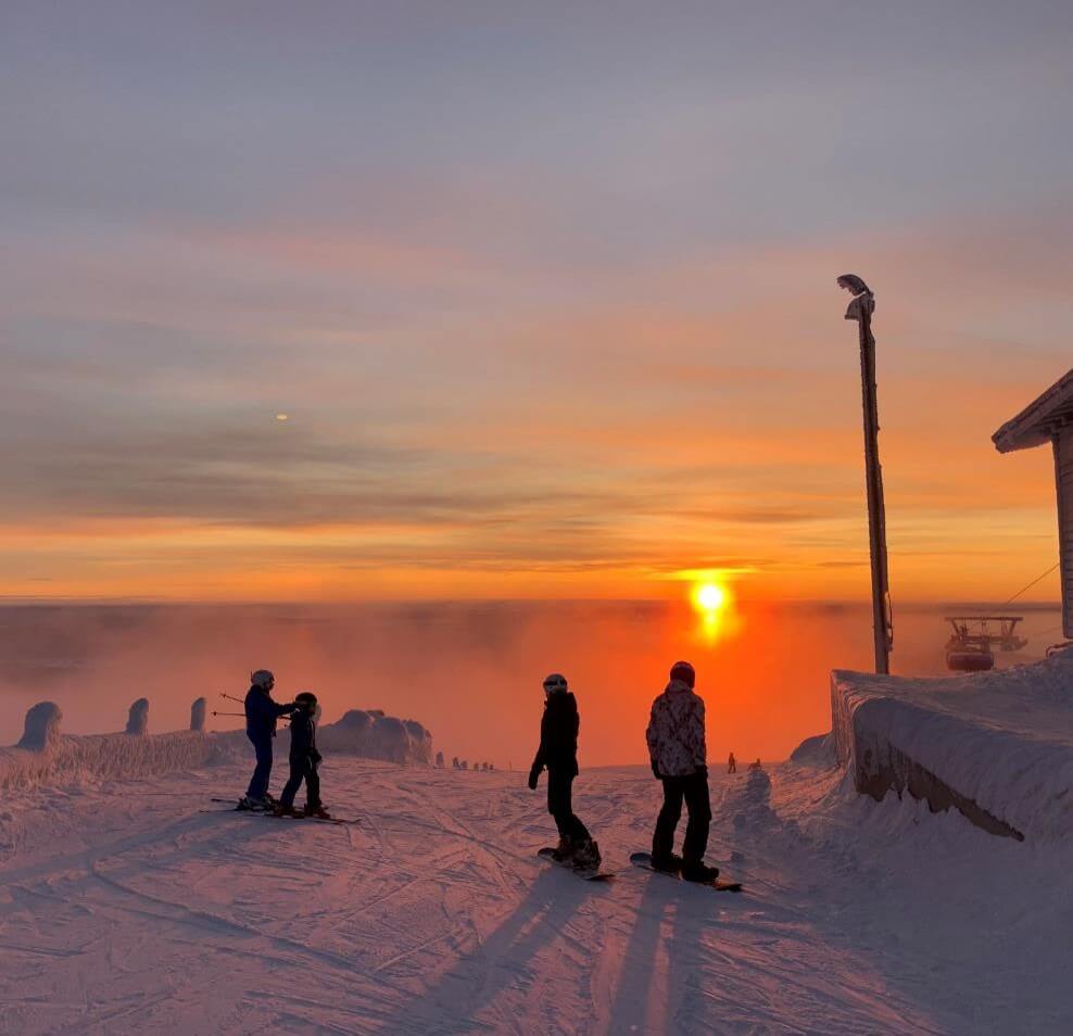 Fjällby – Björkliden in Sweden - a group of people standing on top of a snow covered mountain.